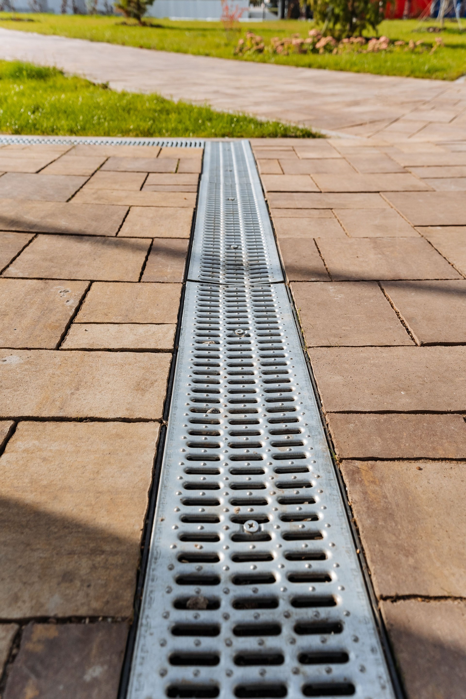 A contemporary outdoor drainage system seamlessly integrated with a beautifully paved pathway designed for efficient water management solutions